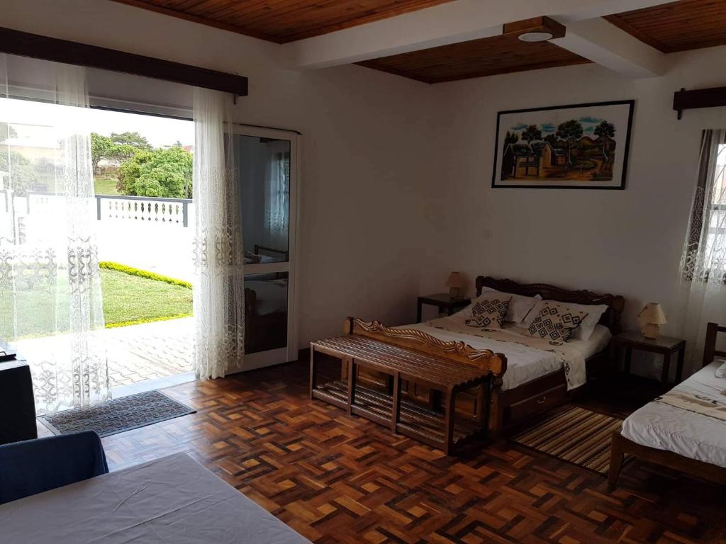 Spacious guest room with wooden furniture and garden access at Chambre d'hôtes Valiha
