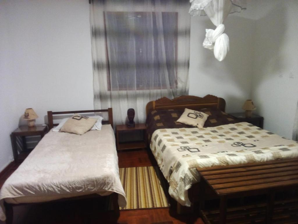 Guest room with double and single beds at Chambre d'hôtes Valiha in Ivato