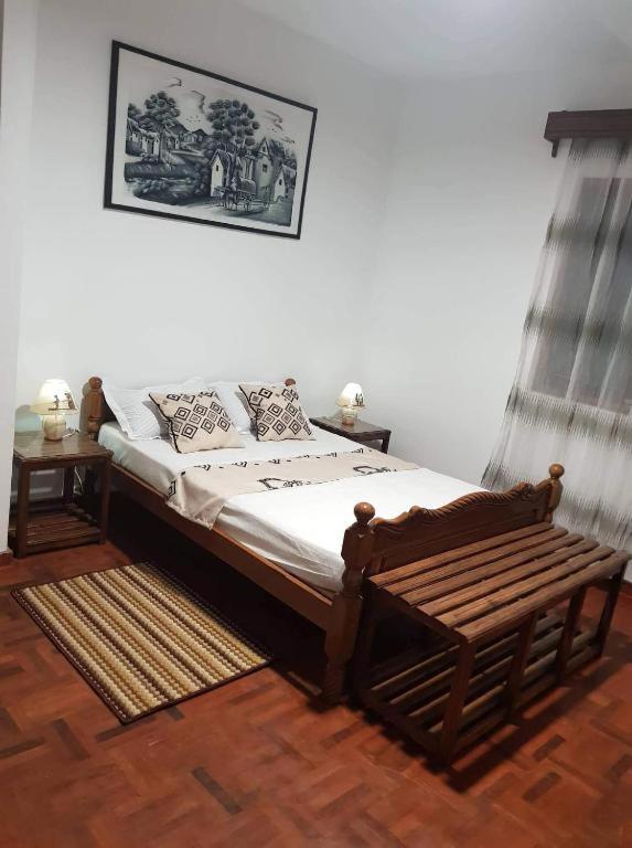 Double room with wooden bed and parquet floor at Chambre d'hôtes Valiha