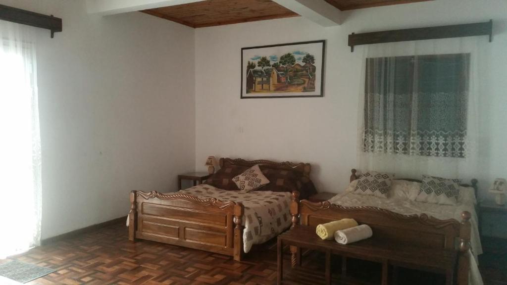 Family-style room with two wooden beds at Chambre d'hôtes Valiha