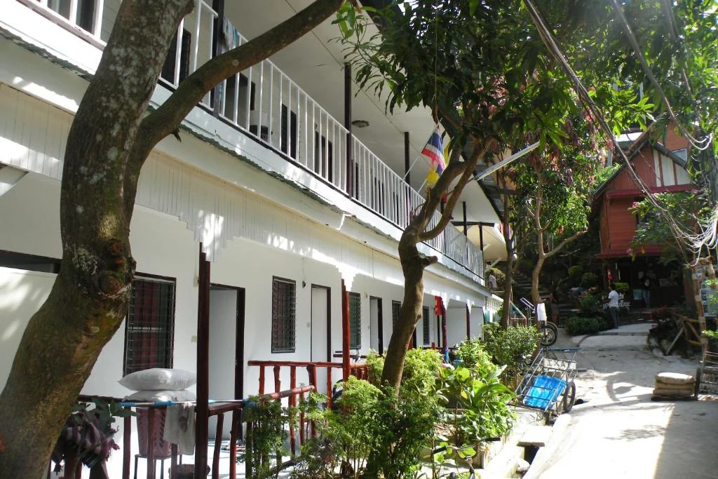 Coco's Guest House exterior walkway surrounded by tropical greenery
