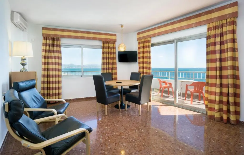 Apartment living area opening onto a private balcony at Hotel Apartamentos Bajondillo