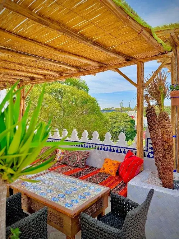 Rooftop terrace lounge with colorful cushions at Riad Al-Qurtubi Tangier