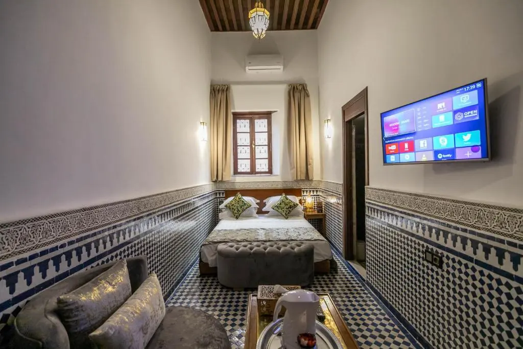 Twin room with television at Riad Fes Ziyat & Spa