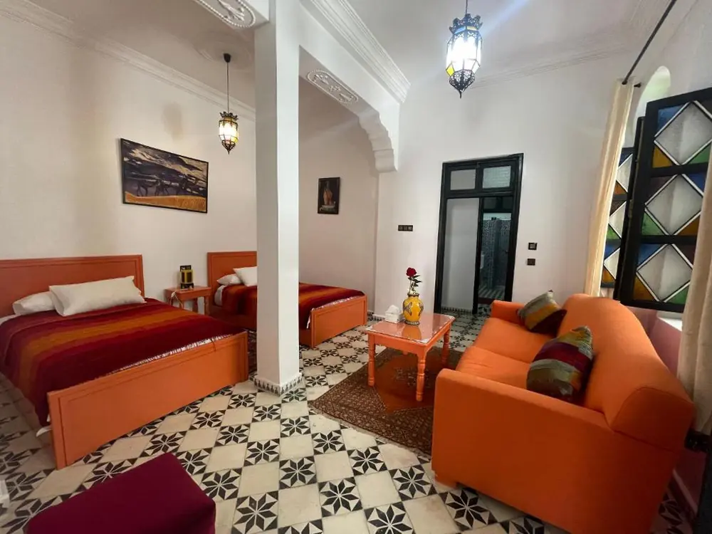 Family room with an orange sofa at Riad Tingis Tangier