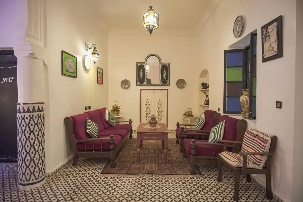 Traditional Moroccan lounge with patterned tile floor at Riad Tingis