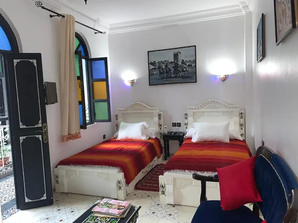 Twin room with colorful bedding at Riad Tingis in Tangier