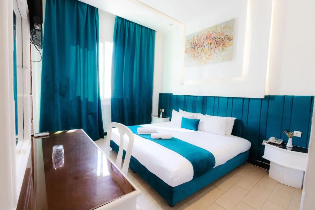 Teal double room with floor-to-ceiling curtains at Windsor Hotel City Center Casablanca
